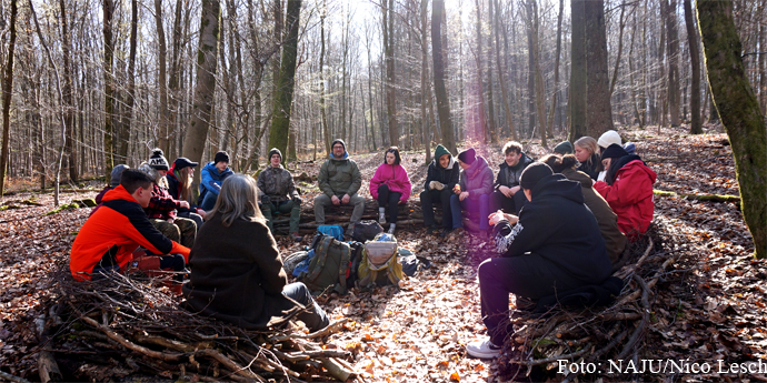 Juleica: Besprechung im Wald - Foto: NAJU/Nico Lesch Die Teilnehmenden sitzen im Kreis im winterlichen Wald